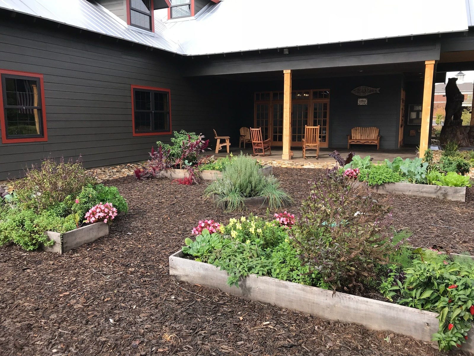 Courtyard install, cedar beds against a black clapboard building