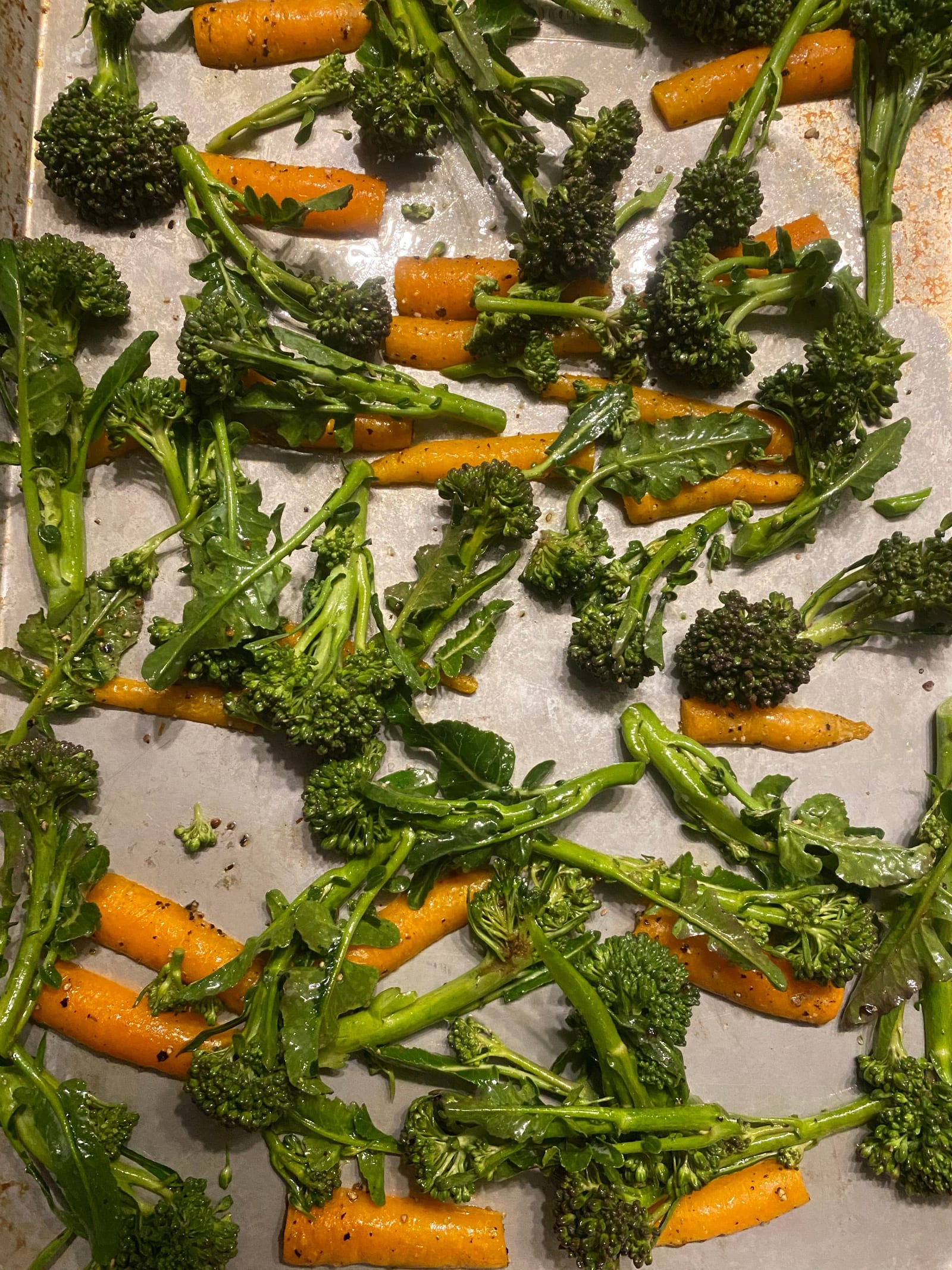 Halved carrots and broccolini roasted cut-side down across a sheet pan